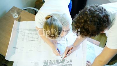 Male and female architects during work with construction schemes