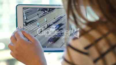Woman using touchpad to make photos of the city traffic