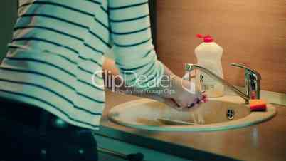 Woman washing dishes in the kitchen at home