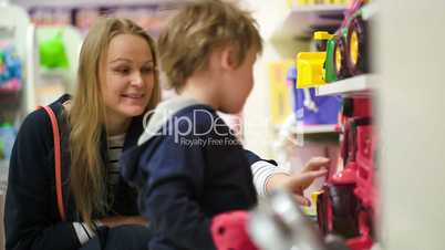 Mother and son choosing toy car in the shop
