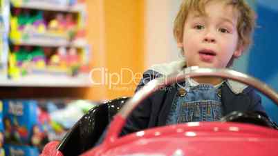 Little boy swinging in a toy car