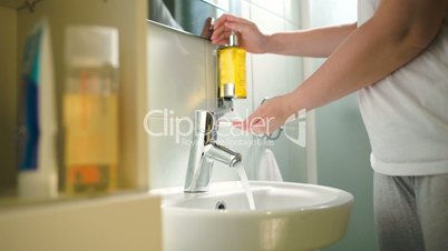 Woman washing hands with liquid soap