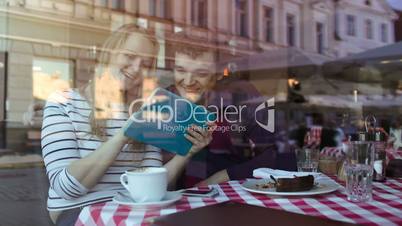 Happy young couple with tablet PC in a cafe