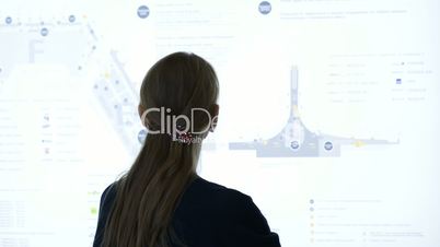Woman exploring schematic map at the airport or trade cemter