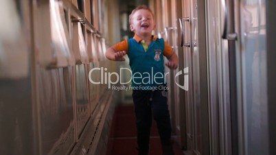 Happy boy running along the train hallway