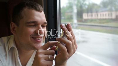 Young man typing sms in moving train