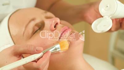 Applying facial mask in beauty treatment salon