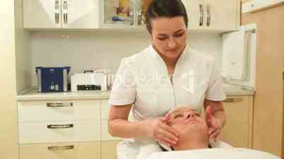 Facial massage seance providing by female cosmetician