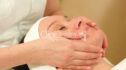 Massage of face at beauty treatment salon