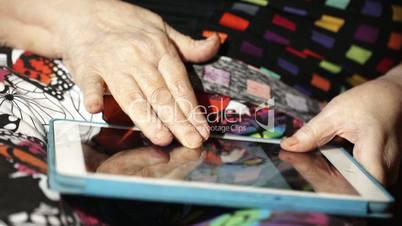 Elderly woman scrolling slowly photos on touchpad