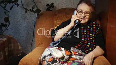 Old woman receiving a phone call in the evening