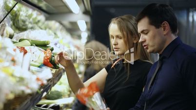 Man and woman buying fresh vegetables in grocery