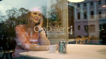Woman talking on mobile phone in cafe