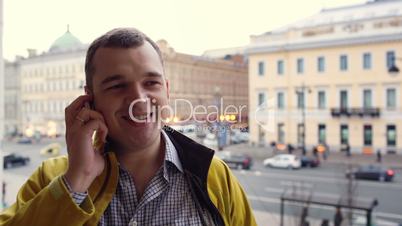 Young excited man talking on the phone outdoor