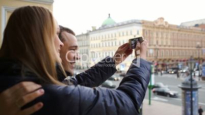 Loving couple having fun making photos of themselves with cell phone
