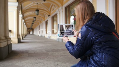 Woman with tablet PC making photo of hall in perspective