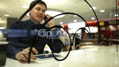 Businessman with pad in cafe talking on the phone