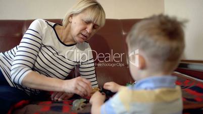 Grandmother and granson playing with toys on the sofa