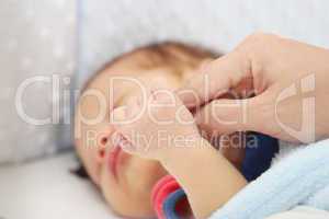 Slept baby hand holding mother finger