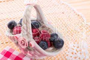 porzelan basket with raspberry and bilberry