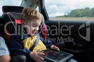 Happy boy playing with touchpad in the car