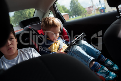 Two boys on the back seat of a car