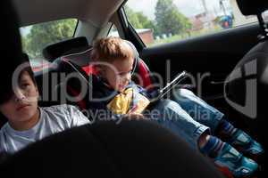 Two boys on the back seat of a car
