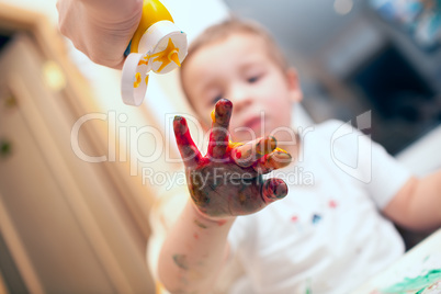 Pressing finger-paint on boys hand