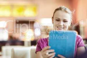 Young happy woman in cafe with tablet PC