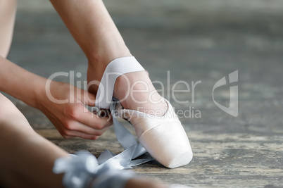 Taking off the ballet shoes after rehearsal or performance