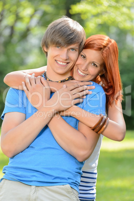 Young loving couple hugging in sunny park