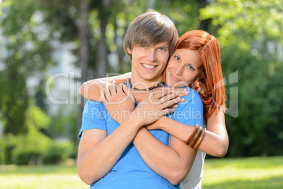 Young loving couple embracing in sunny park