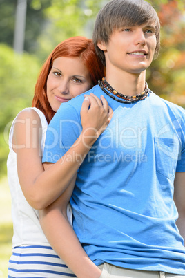 Teenage girlfriend hugging her boyfriend in park