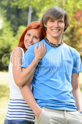 Teenage girlfriend embracing her boyfriend in park