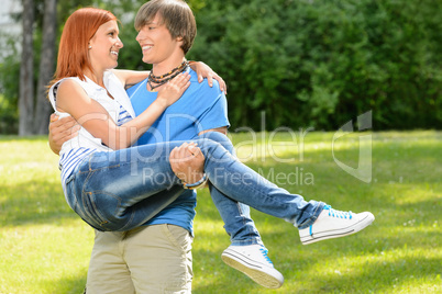 Teenage boyfriend carry girlfriend in his arms