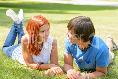 Couple lying on grass looking each other