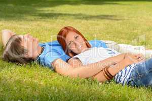 Teenage couple enjoying sun lying on grass