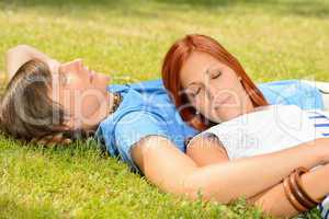 Teenage couple relaxing on grass closed eyes
