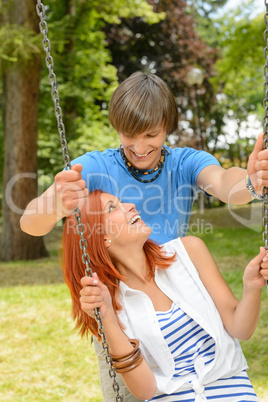 Boyfriend and girlfriend enjoying date on swing