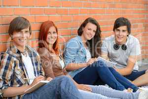 Group of friends students sitting in row