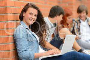 Student girl outside campus with laptop friends