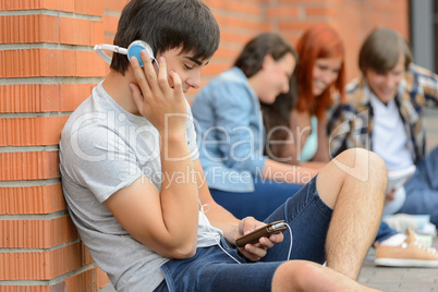 Student boy with headphones friends outside campus