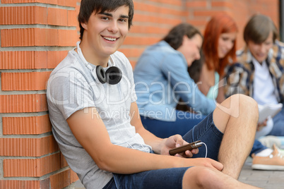 College student boy sitting ground with friends