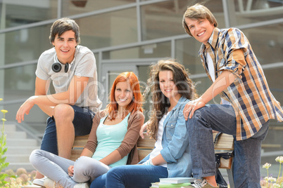 Group of students sitting bench front college