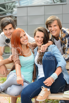 Cheerful friends hanging out by college campus