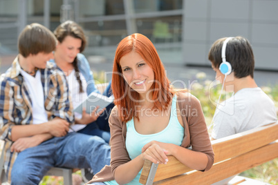 Student girl sitting outside campus with friends