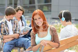 Student girl sitting outside campus with friends