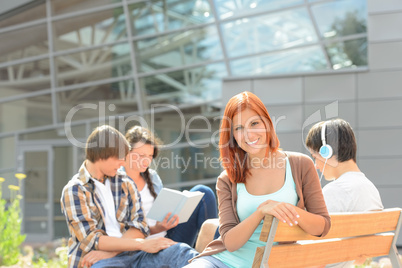 Smiling student girl with friends outside college