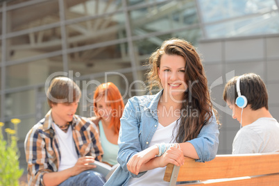 Student girl sitting outside campus with friends