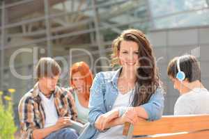 Student girl sitting outside campus with friends